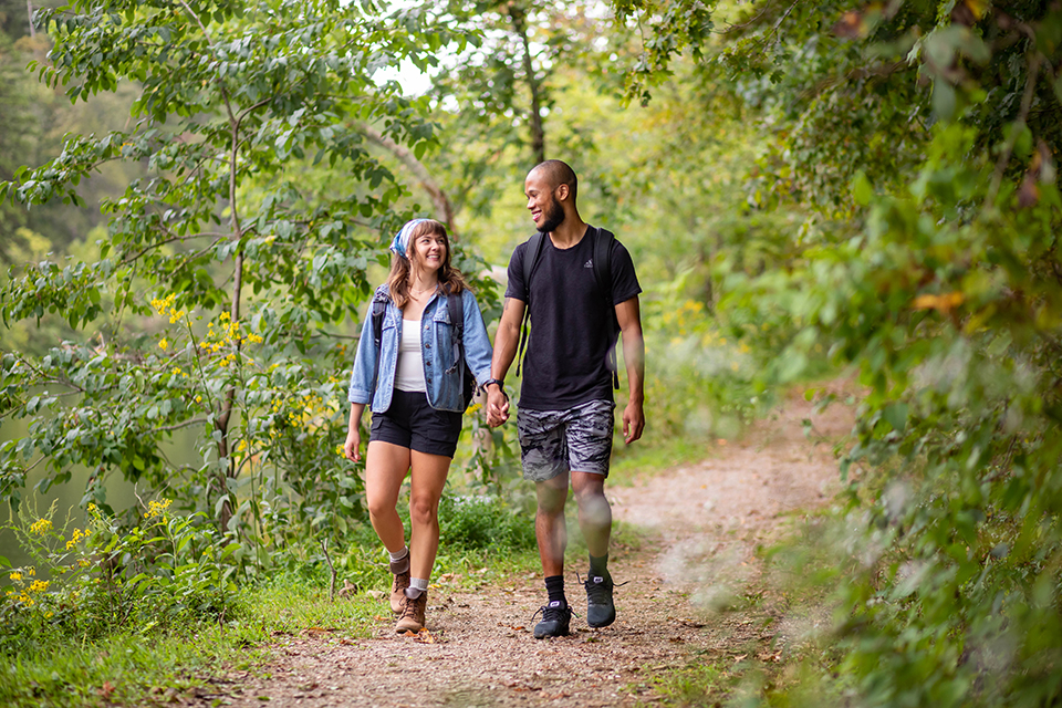 Hiking couple lake background holding hands_five